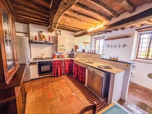 A kitchen with a stove, oven, sink, and a window.