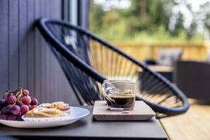 Une table avec une assiette de nourriture, une tasse de café et une chaise.
