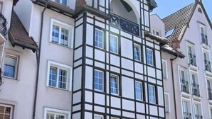 A building with a traditional European architectural style, featuring a prominent corner with a black and white facade. - Penthouse in the old Citycenter (Kolobrzeg)