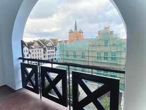 A balcony with a view of historic buildings and scaffolding. - Penthouse in the old Citycenter (Kolobrzeg)