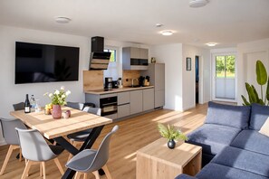 A modern kitchen with a dining area, a sofa, and a TV. - Holiday Apartment 903 in Winterberg – The Accommodation for Large Families (Winterberg)