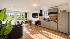 Una cocina moderna con comedor, ventanas amplias y vistas a zonas verdes.