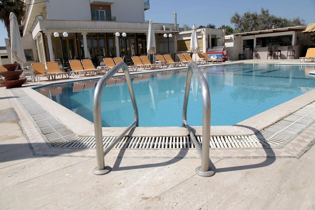 A swimming pool with lounge chairs and a bar area.
