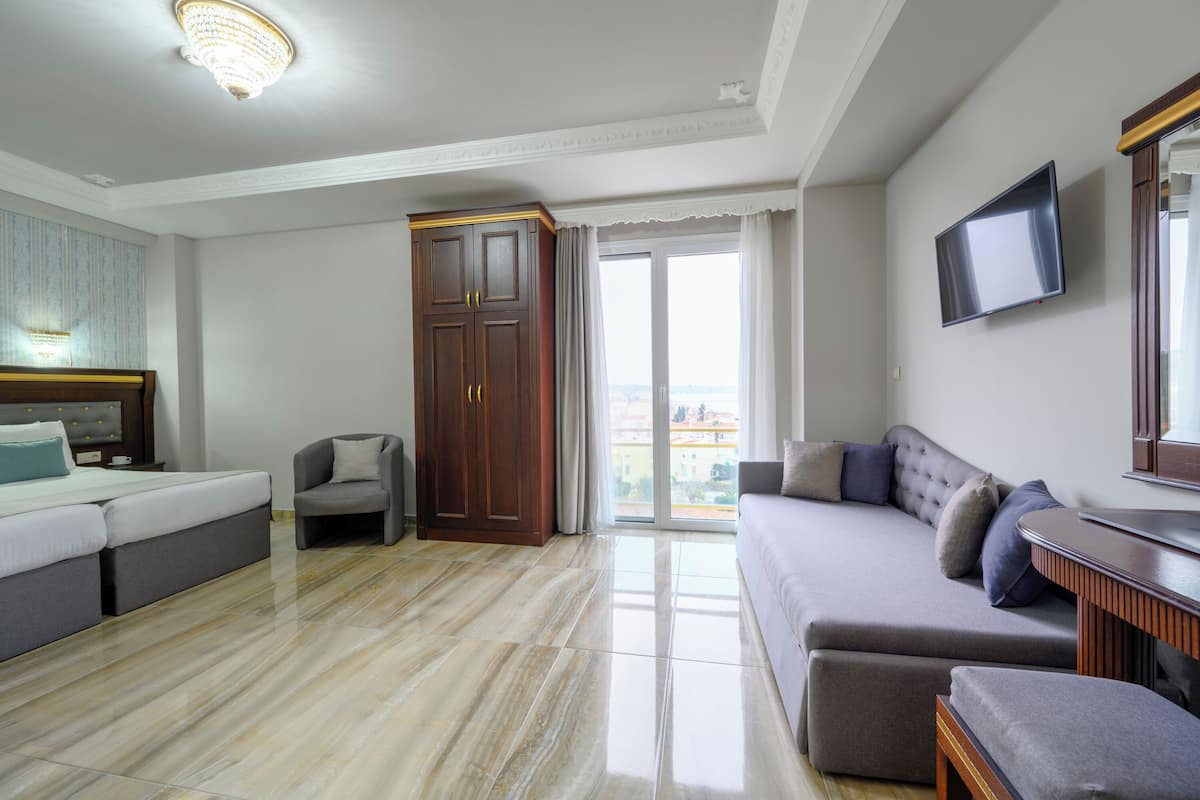 A modern living room with a sofa, a chair, a TV, and a wardrobe.
