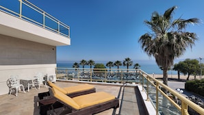 A rooftop terrace with two sun loungers, a glass balustrade, and a view of the sea. - EONA BEACH RESORT by Greek Pride (Thermaikos)