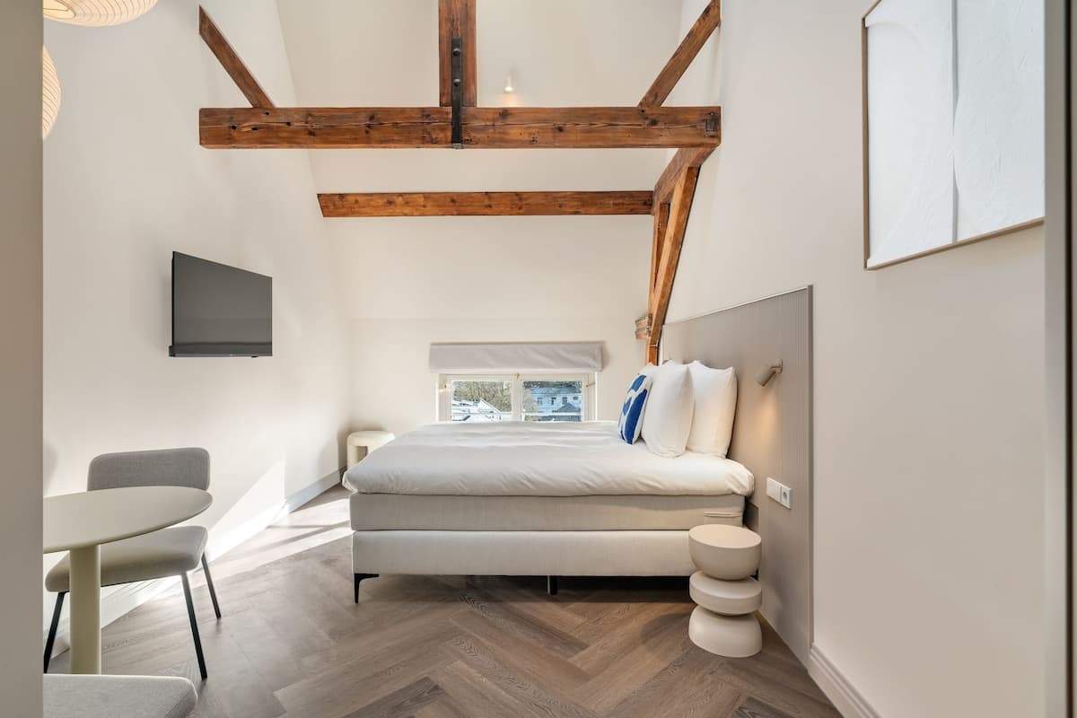 Ein modernes Schlafzimmer mit Bett, Nachttisch und Fenster.