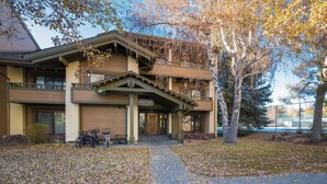 A two-story building with a covered porch and a stone wall. - Condo with Fireplace and Mountain Views! Close to Sun Valley Village! (Sun Valley)
