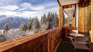 A wooden balcony with a view of snow-covered mountains and trees. - Pleasant Apartment With Shared Sauna (Mittersill)