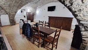 Ein rustikaler Essbereich mit einem Steingewölbe, einem Holztisch und Stühlen.