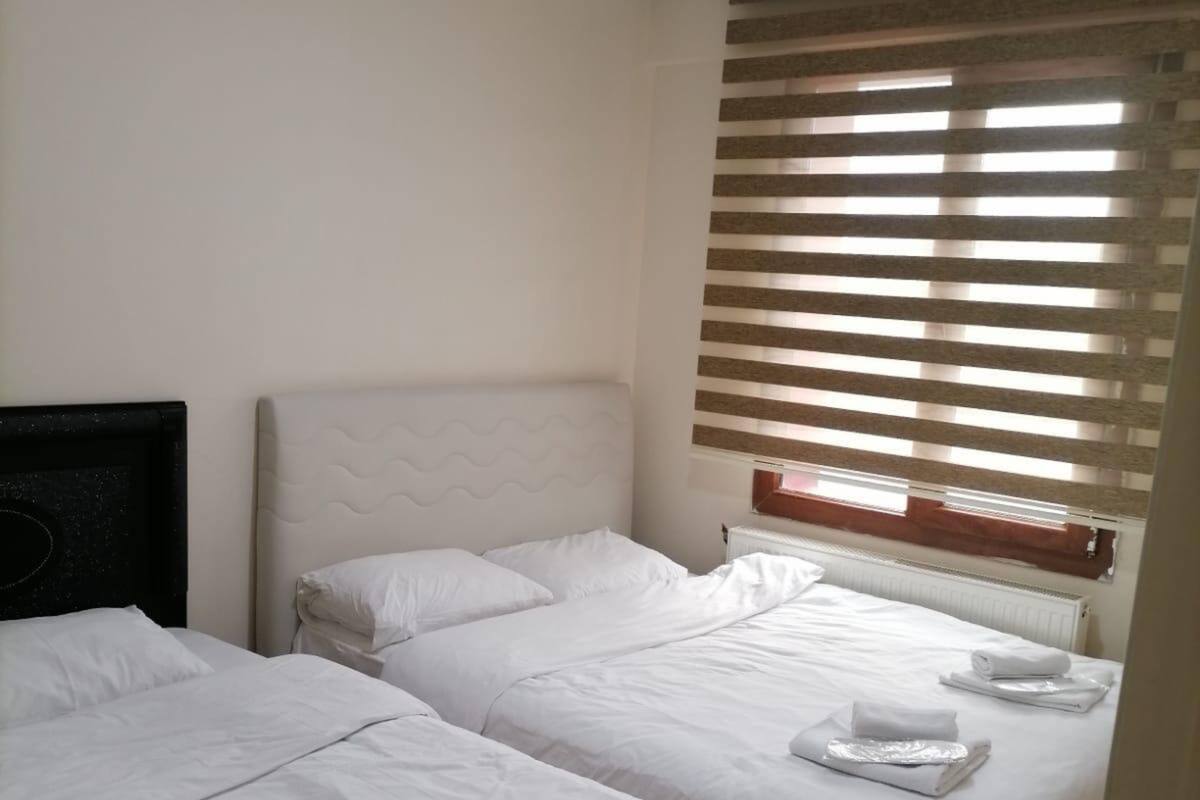 Une chambre d’hôtel avec deux lits, chacun étant équipé de draps et de serviettes blancs.