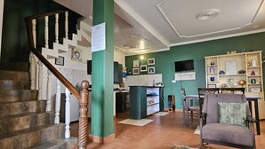 Amplia sala de estar con una escalera, un área de cocina y una zona de estar con una mesa de centro.