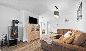 Una sala de estar moderna con chimenea, sofá y mueble de madera.