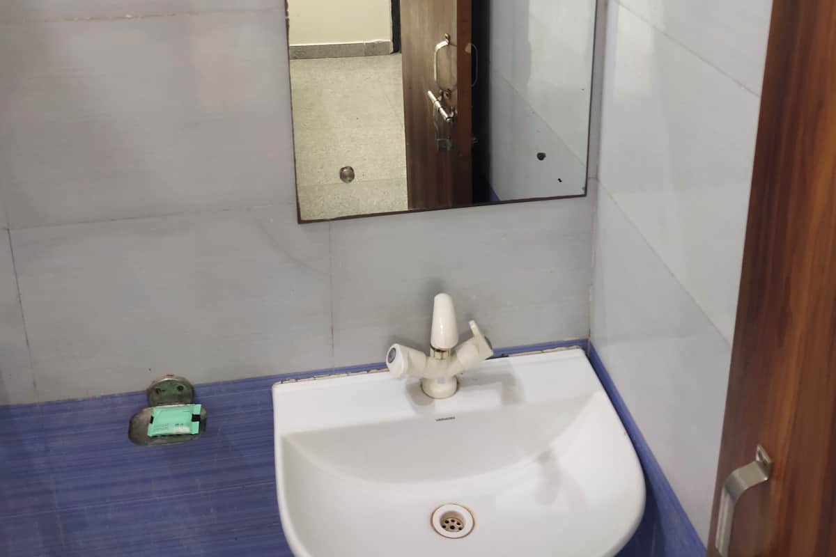A bathroom with a white sink, a mirror, and a blue floor.