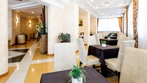 A hotel lobby with a modern design, featuring a reception area, seating arrangements, and decorative plants. - Hotel Palm Beach (Rimini)
