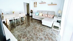 A modern living room with a dining area, white walls, and a marble floor. - Aperol Apartment - Malaga (Málaga)
