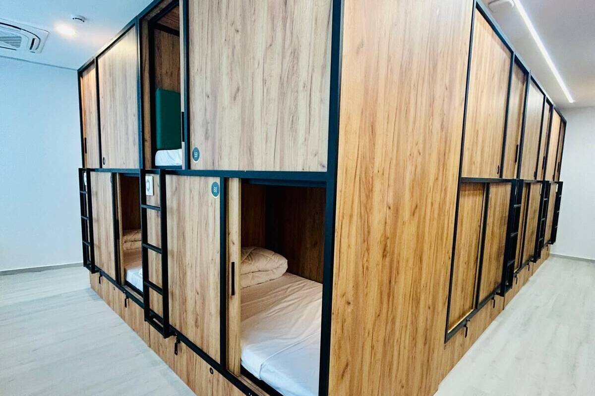 A modern room with a wooden bunk bed and a desk area.