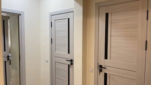 A hallway with two wooden doors, one with a sliding mechanism and the other with a traditional door. - Chaqar 317 (Tashkent)
