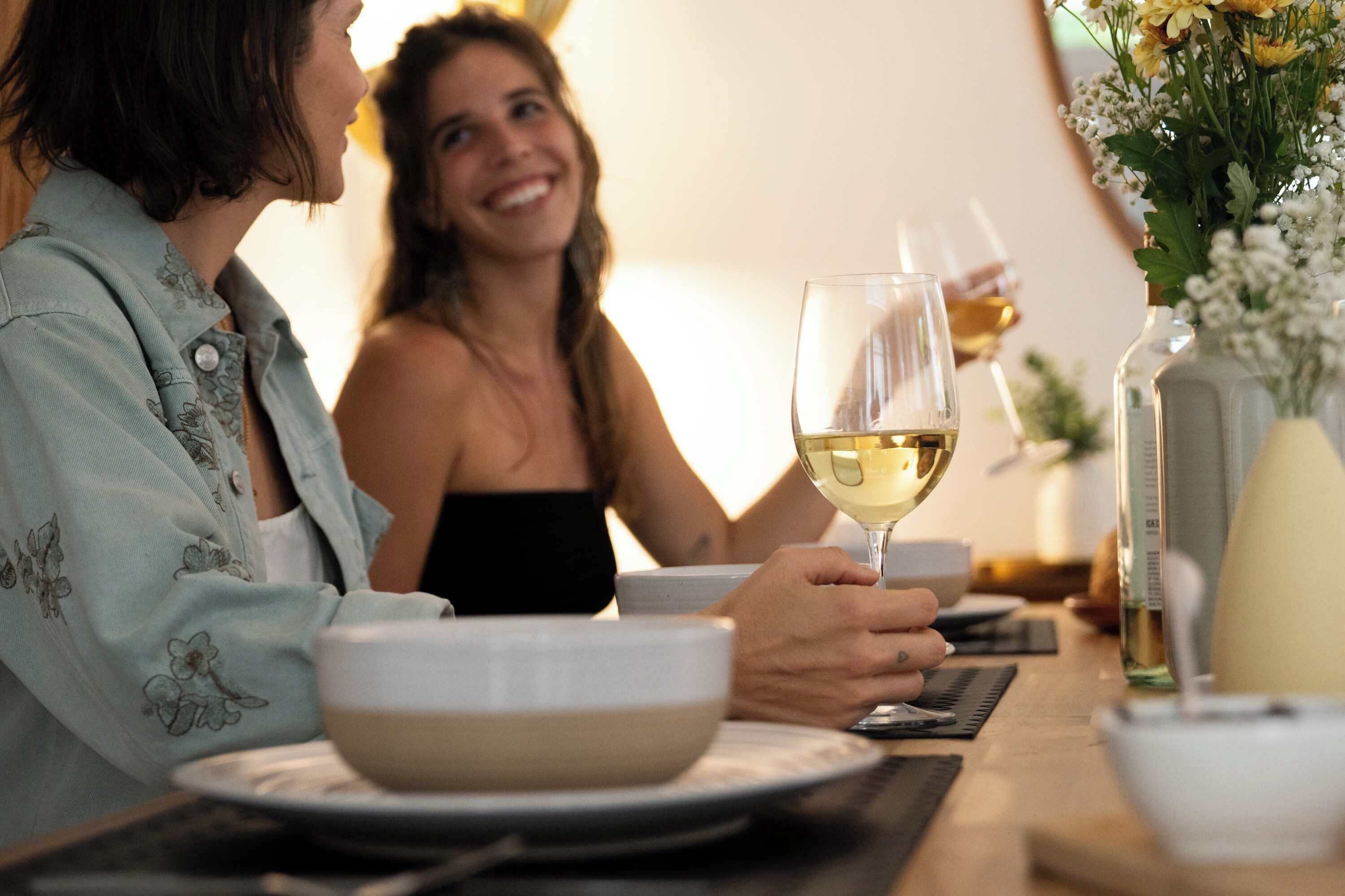 Une table à manger avec un saladier, un verre à vin et une bouteille.