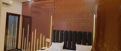 A modern bedroom with a bed, a wall with vertical slats, and a textured wall.