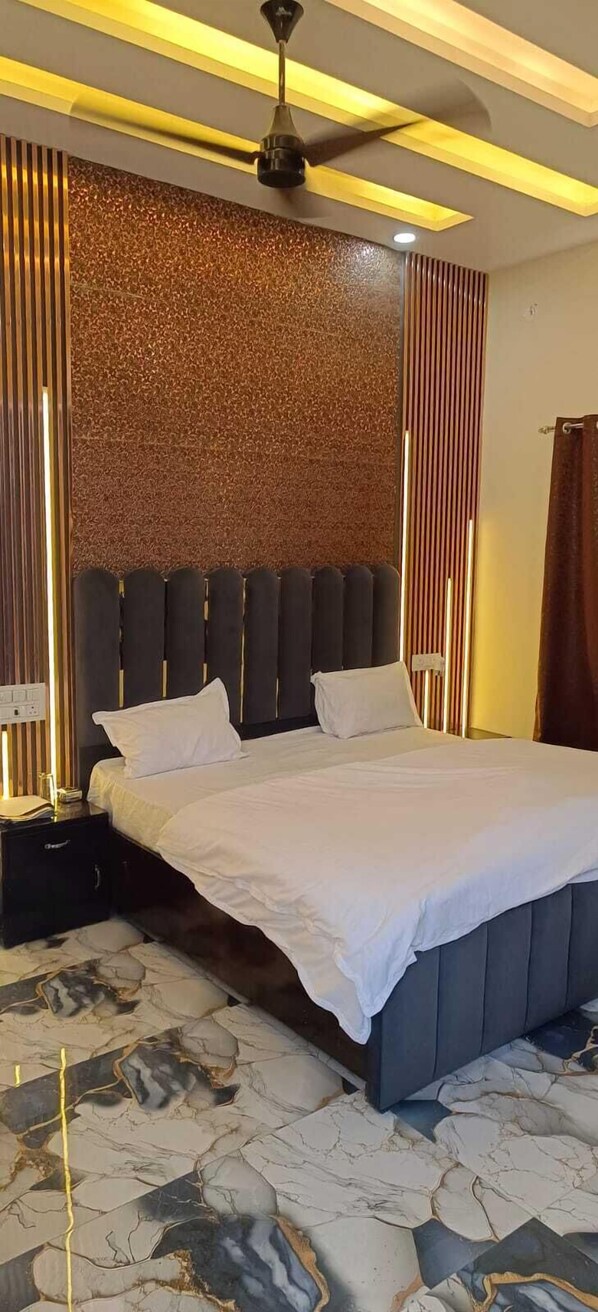 A modern bedroom with a large bed, a ceiling fan, and a patterned floor.