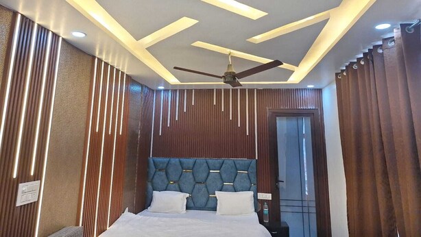 A modern hotel room with a bed, a ceiling fan, and a door. - Hotel The Shivraat (Rishikesh)
