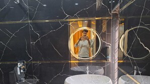 A bathroom with a marble vanity, a sink, and a mirror with a gold frame. - Hotel The Shivraat (Rishikesh)