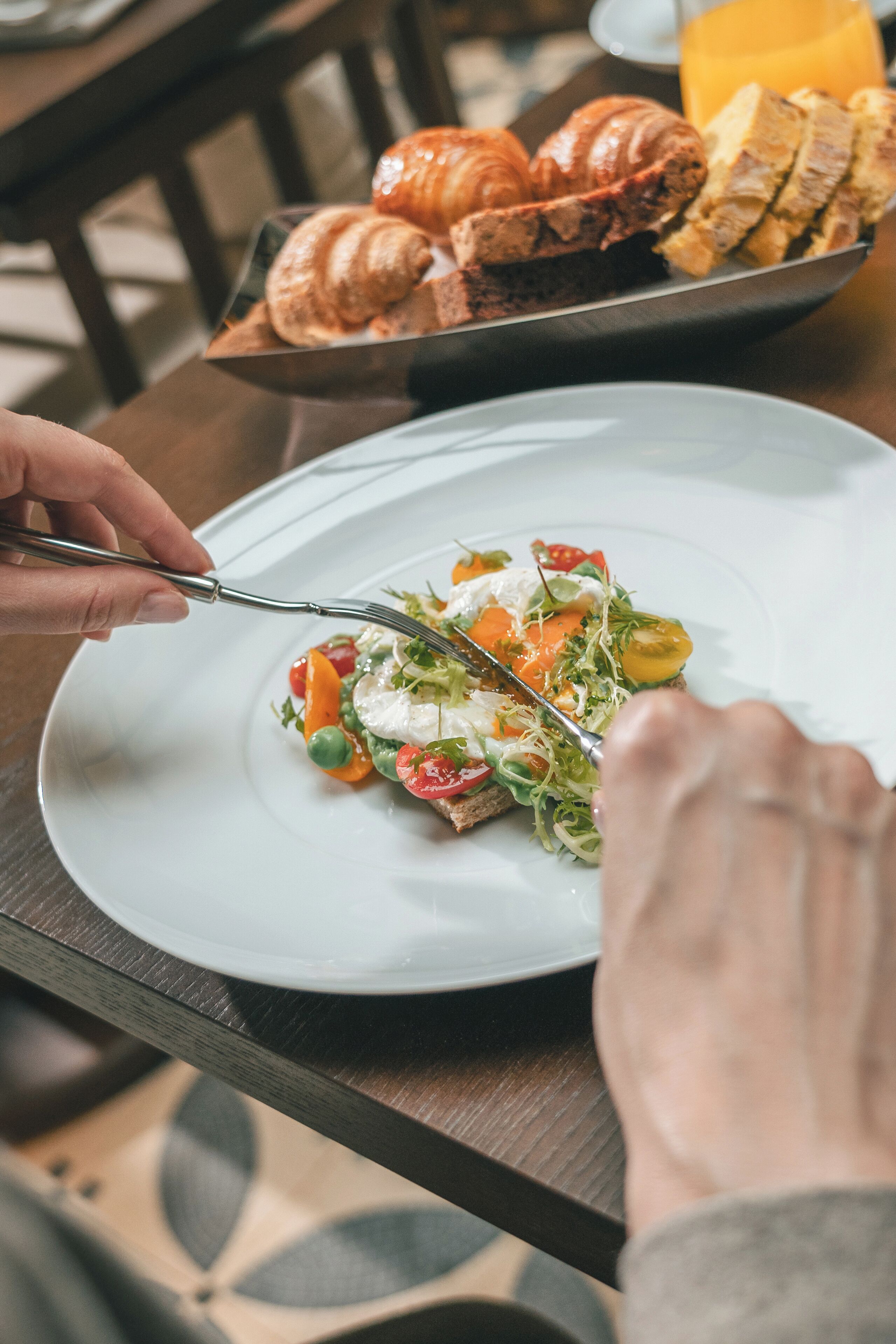 A dining table with a plate of food, a fork, and a knife.