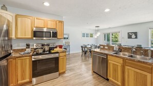 Une cuisine moderne avec des meubles en bois, des appareils électroménagers en acier inoxydable et un îlot central.