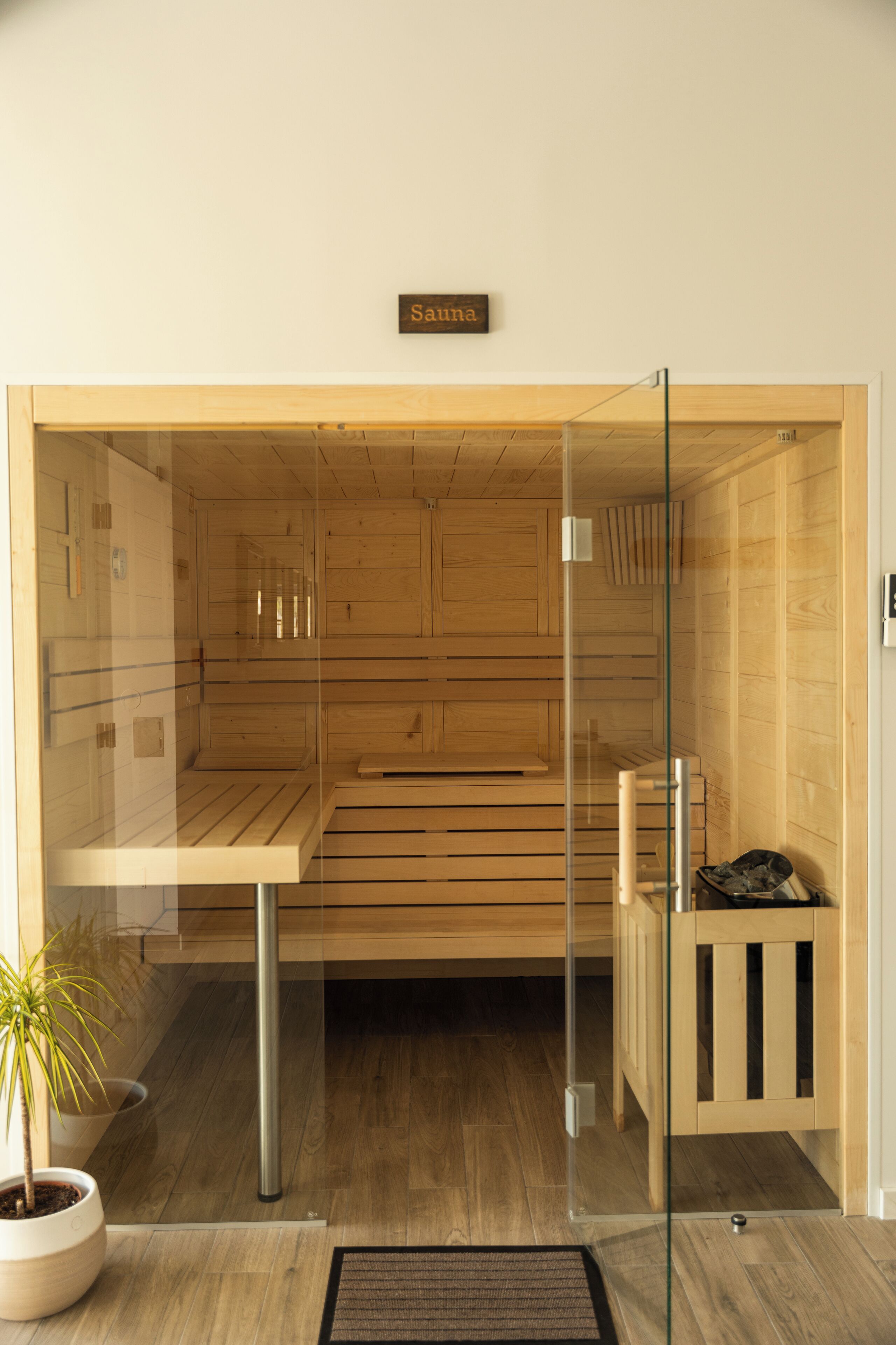 A sauna room with wooden benches and a glass door.