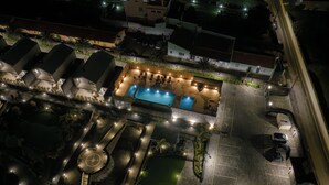An aerial view of a hotel with a swimming pool, outdoor seating, and a parking area. - Azores Homes Resort & Spa (Ponta Delgada)