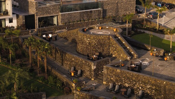 A courtyard with stone walls, outdoor seating, and a star-shaped design. - Azores Homes Resort & Spa (Ponta Delgada)