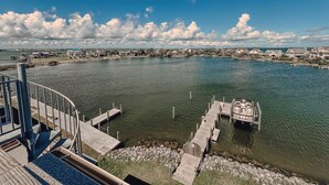 Propiedad frente al agua con muelle, un bote y vistas del vecindario circundante.