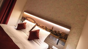A hotel room with a bed, two red pillows, a headboard with a cityscape mural, and a nightstand. - Hotel Golden Pearl Magdeburg Im Stadtzentrum (Magdeburg)