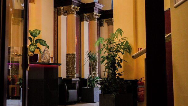 A lobby with a chandelier, columns, and potted plants. - Hotel Golden Pearl Magdeburg Im Stadtzentrum (Magdeburg)