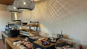 Ein reichhaltiges Frühstücksbuffet mit einer Auswahl an Speisen, darunter Backwaren, Früchten und Getränken.