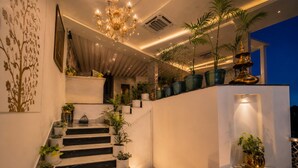 Una escalera adornada con numerosas macetas, un candelabro y un elemento decorativo en la pared.
