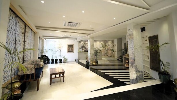 A spacious lobby with a central seating area, a staircase, and decorative wall panels. - Grandrosse Boutique - Lake Facing Hotel (Udaipur)