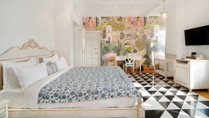A bedroom with a bed, a desk, a chair, and a television. - Grandrosse Boutique - Lake Facing Hotel (Udaipur)