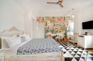 Un dormitorio con cama, escritorio, silla y televisor.