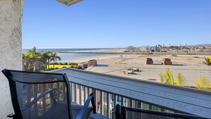 Un balcon avec vue sur une plage et l’océan.