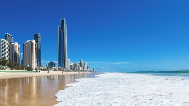 Une plage avec la silhouette d’une ville en arrière-plan.