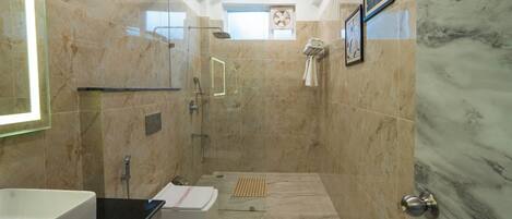 A modern bathroom with a glass-enclosed shower, a white bathtub, and a large sink.