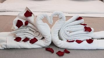 Una cama bien hecha con almohadas blancas y un cabecero color beige.