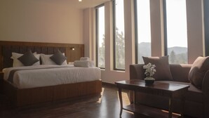 Een slaapkamer met een groot bed, een houten hoofdbord, een sofa en een tafel met een bloevas.