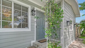A house with a gray exterior, a front door, and a small porch area with steps leading up to the door.