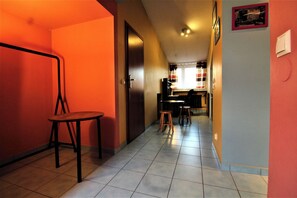 Enter a cozy dining space with a wooden chair and table, leading to a warm and inviting area with a window.