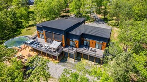 A modern two-story house with a pool, outdoor seating, and a deck. - Luxurious Retreat | Private Creek View | Hot Tub (Hot Springs)