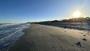 Ein Strand mit klarem Himmel und der Sonne, die am oder über dem Horizont untergeht oder aufgeht.