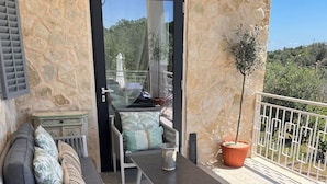 A stone-walled outdoor seating area with a sofa, chairs, and a table. - Beautiful villa with scenic views, located between Ostuni & Cisternino. (Ostuni)