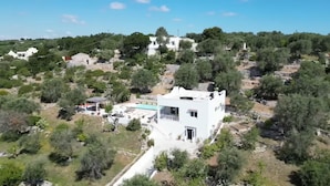 A white villa with a balcony, surrounded by trees and a pool. - Beautiful villa with scenic views, located between Ostuni & Cisternino. (Ostuni)